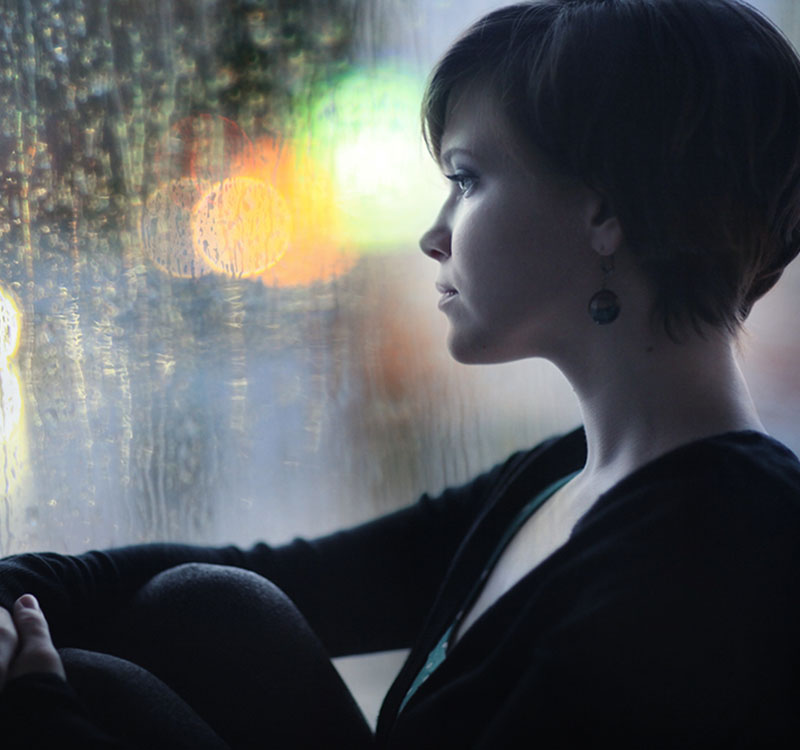 sad girl on the windowsill looking out the window Charlotte, NC 28204